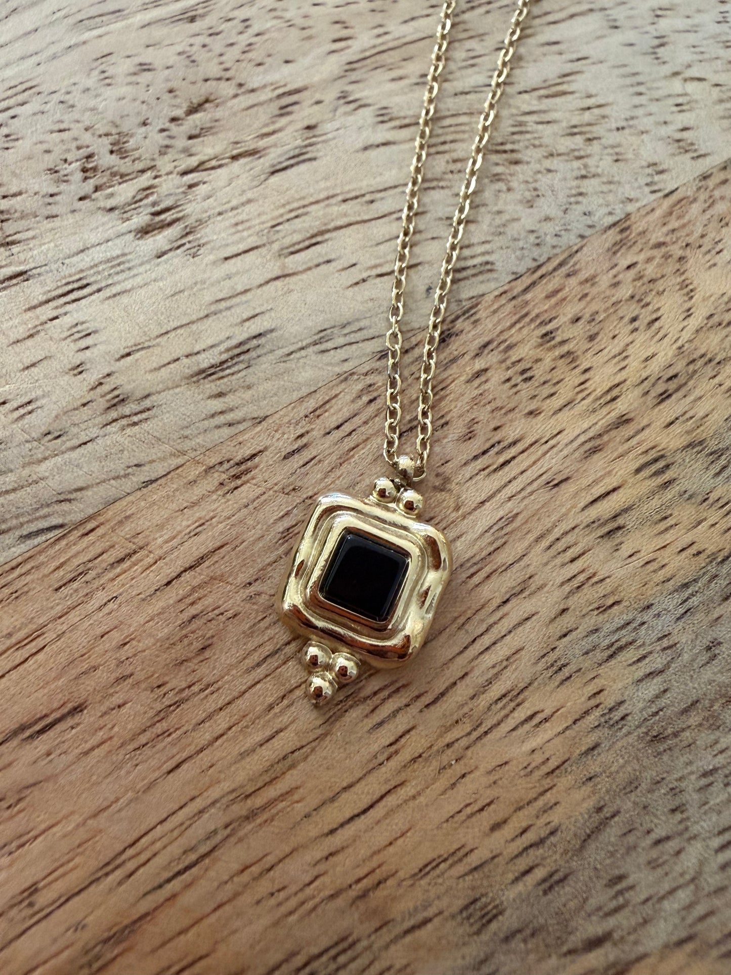 Collier doré pendentif noir